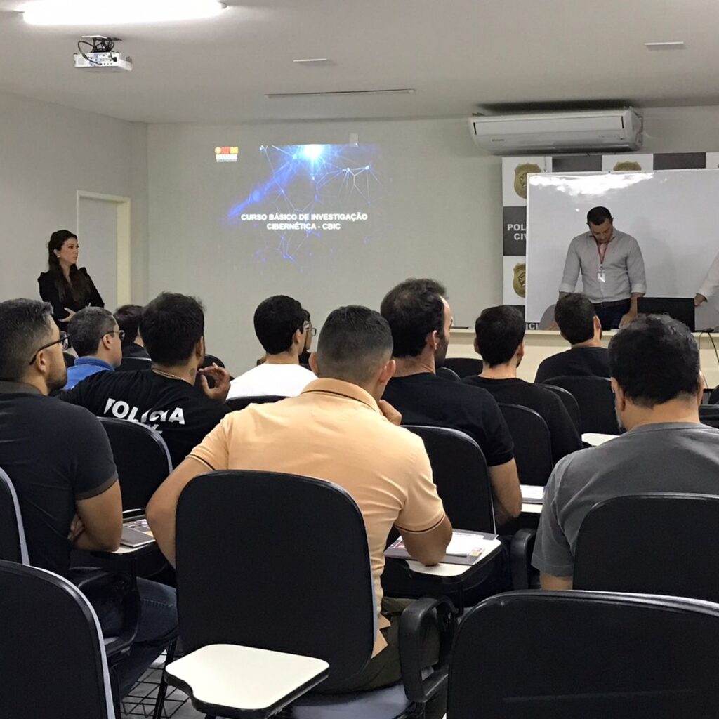 Imagem de pessoas sentadas em um auditório, participando de um curso.