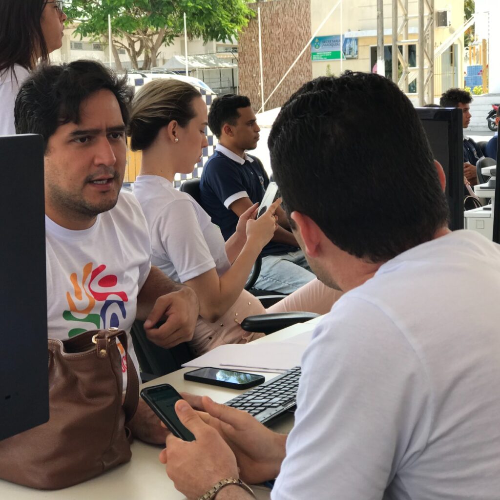 Imagem de dois homens sentados à mesa, conversando.