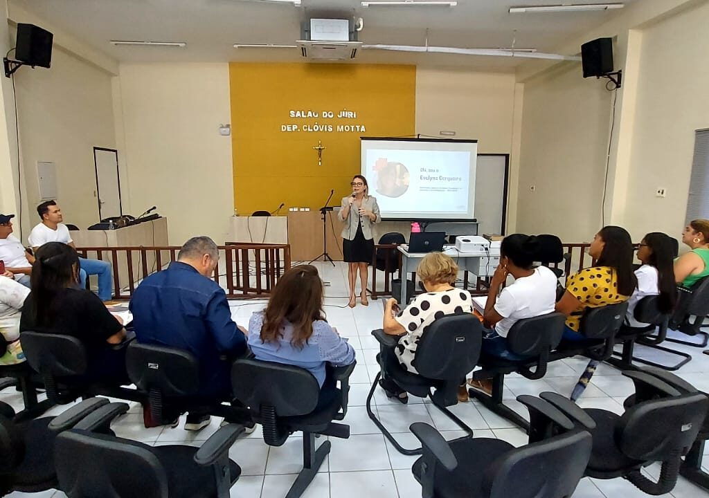 Imagem com várias pessoas sentadas em semi-círculo, assistindo a uma palestra