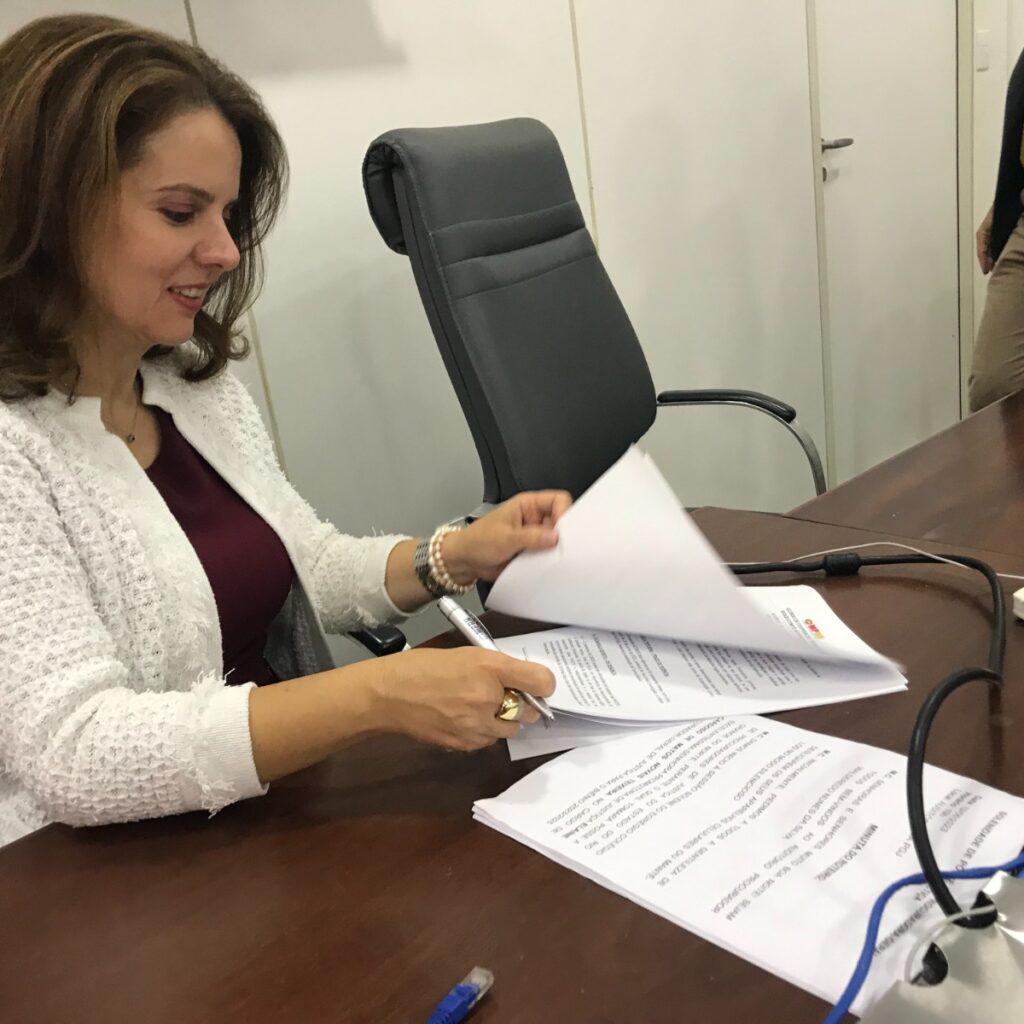 Imagem da procuradora-geral de Justiça Elaine Cardoso assinando um documento