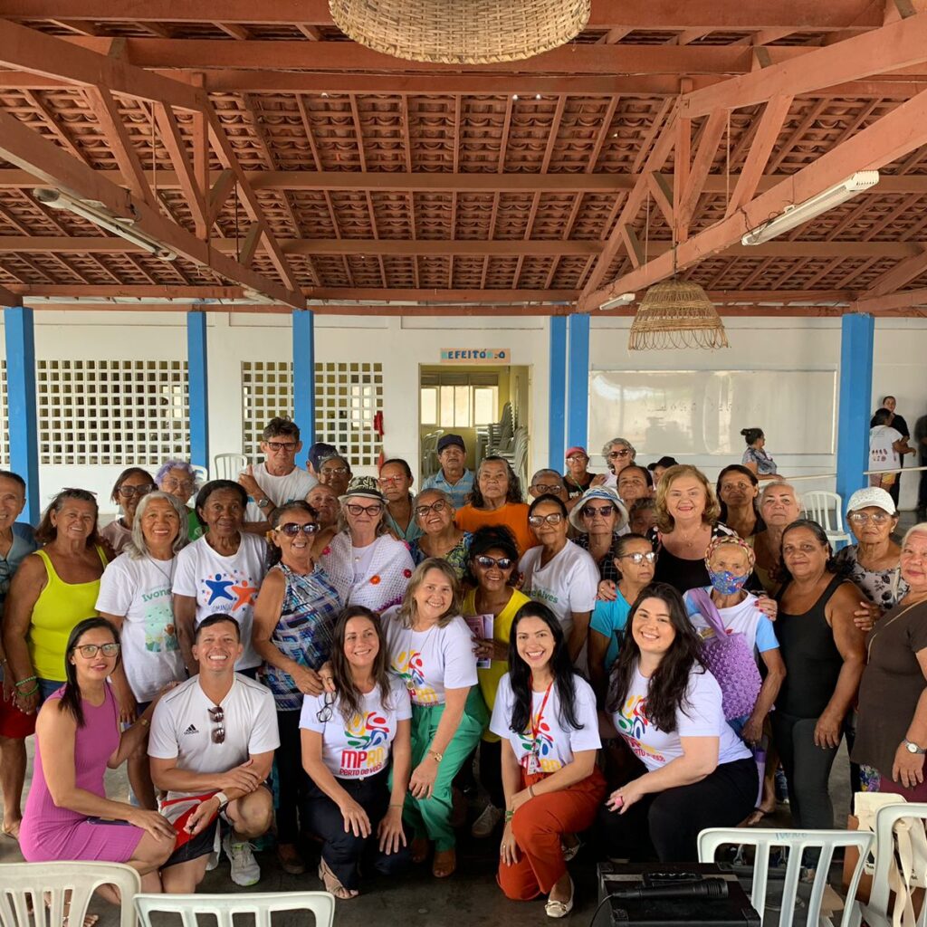 Imagem de várias pessoas, em um pátio, durante evento em uma instituição de longa permanência para pessoas idosas.