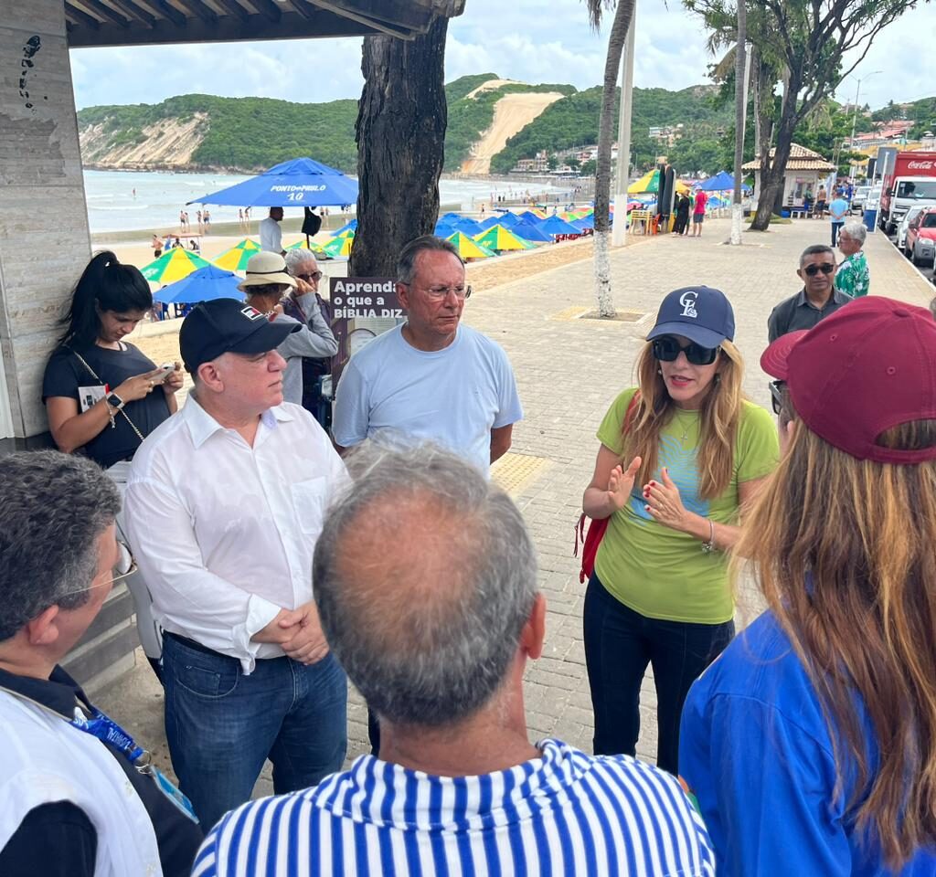 Imagem feita no calcadão da praia de ponta negra com o morro do careca aos fundos e no primeiro plano autoridades conversando em circulo.