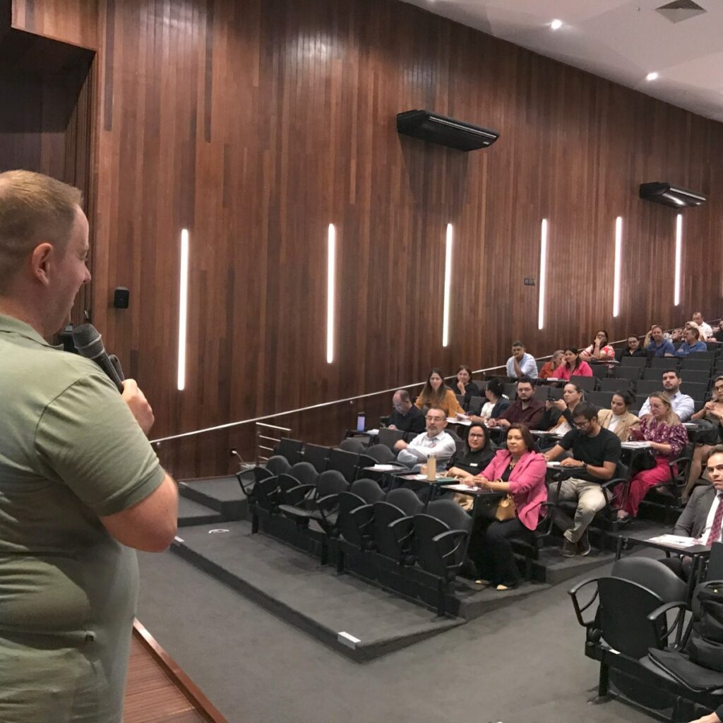 Imagem do auditório da Procuradoria-Geral de Justiça com um homem falando para a plateia.