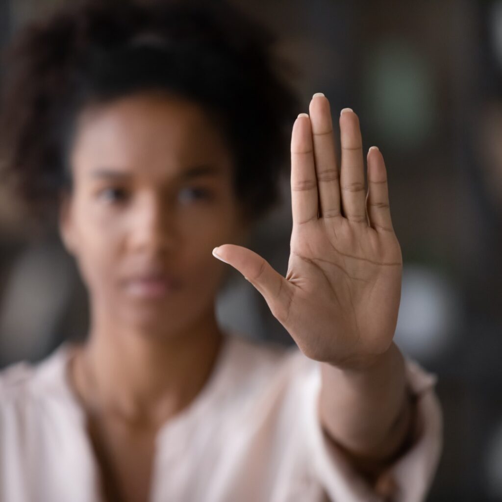 imagem de mulher desfocada com a mão levantada em sinal de pare