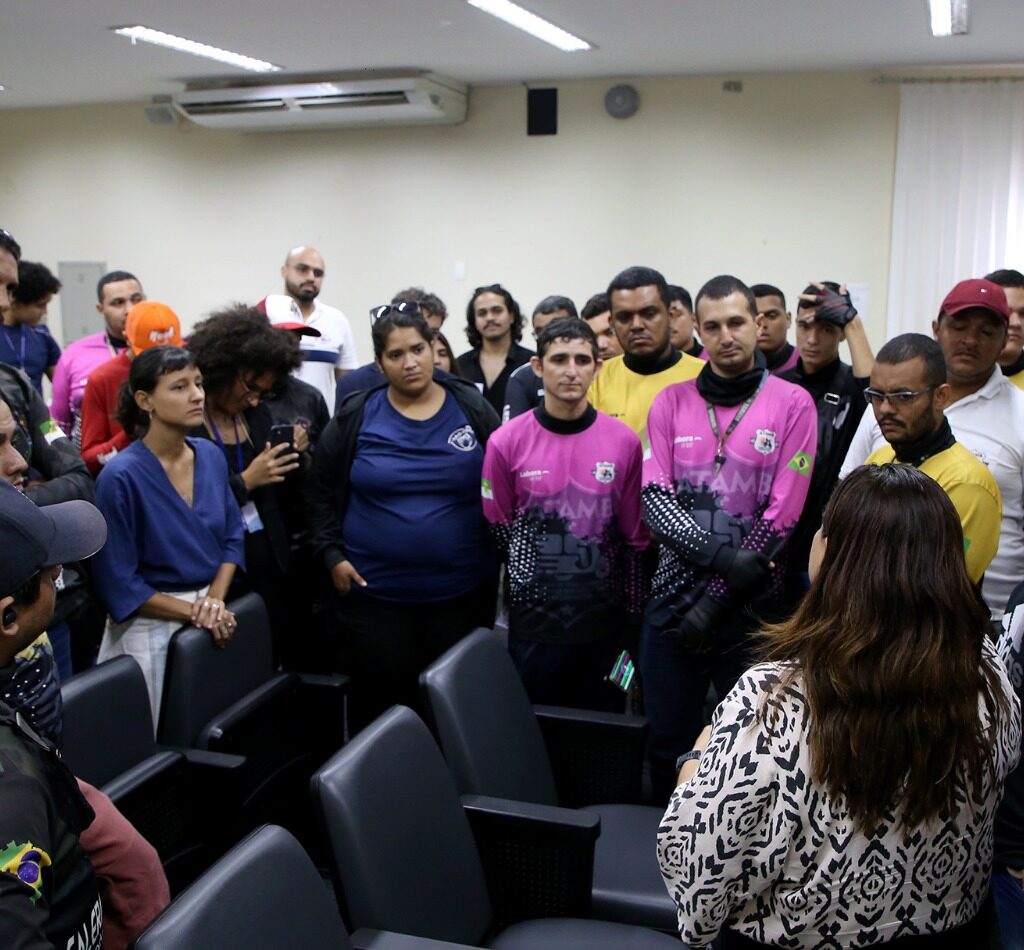 Imagem de motoentregadores conversando com a promotora de Justiça Danielle Veras.