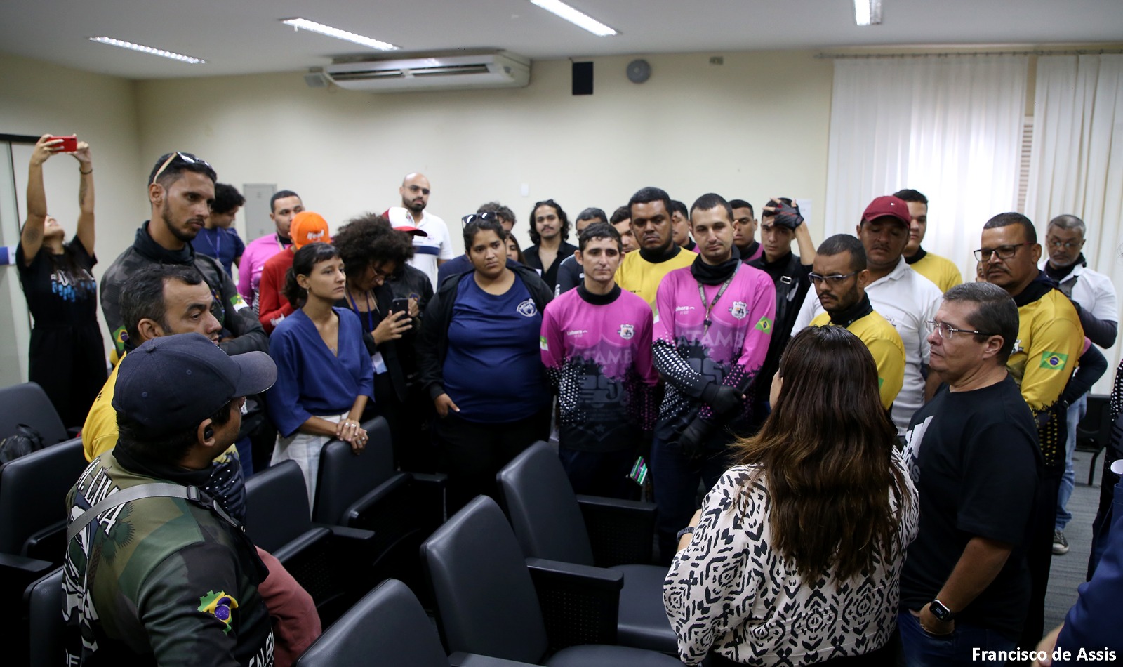 Imagem de motoentregadores conversando com a promotora de Justiça Danielle Veras.