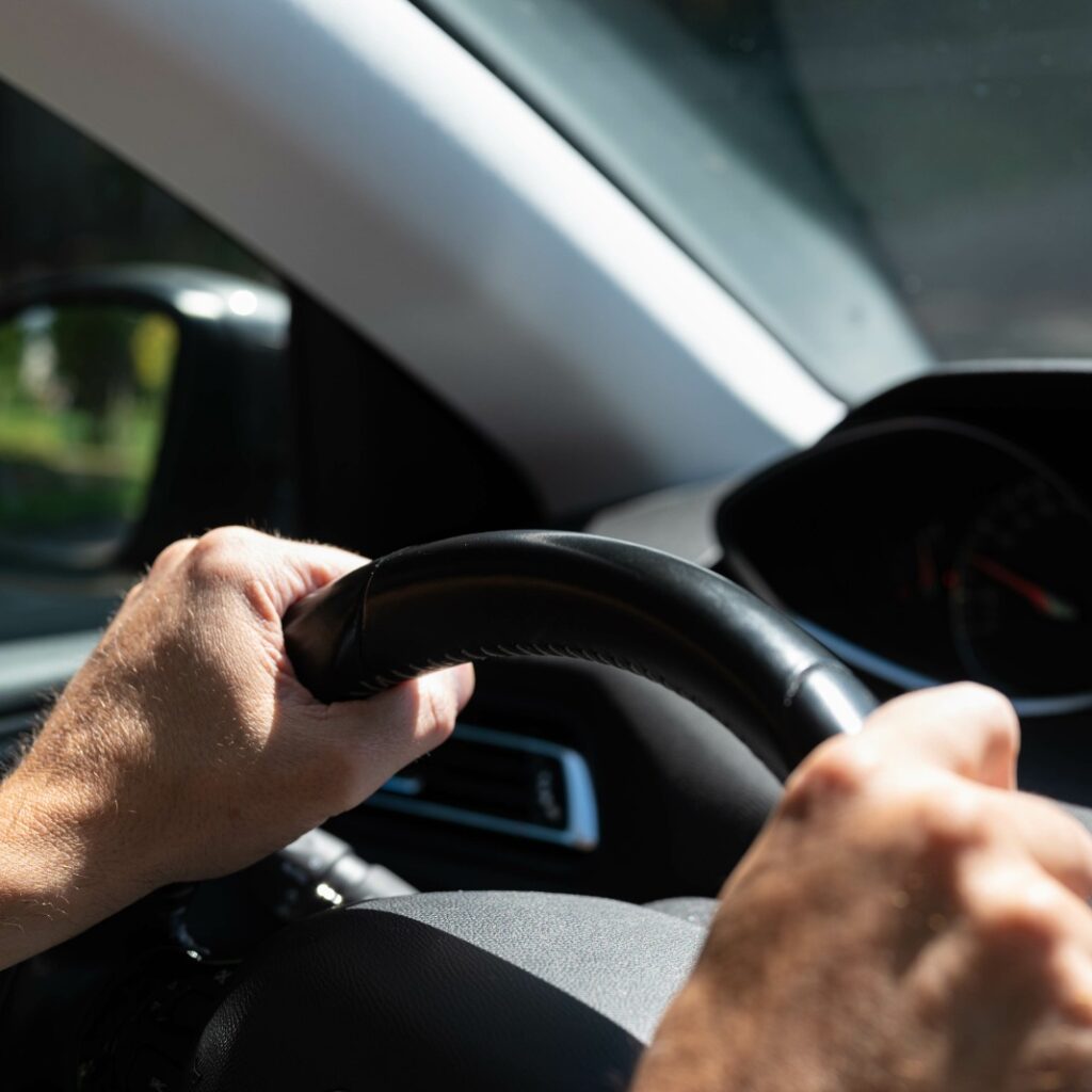 motorista com a mão no volante de um carro em alusão à recomendação para uso regular de frota