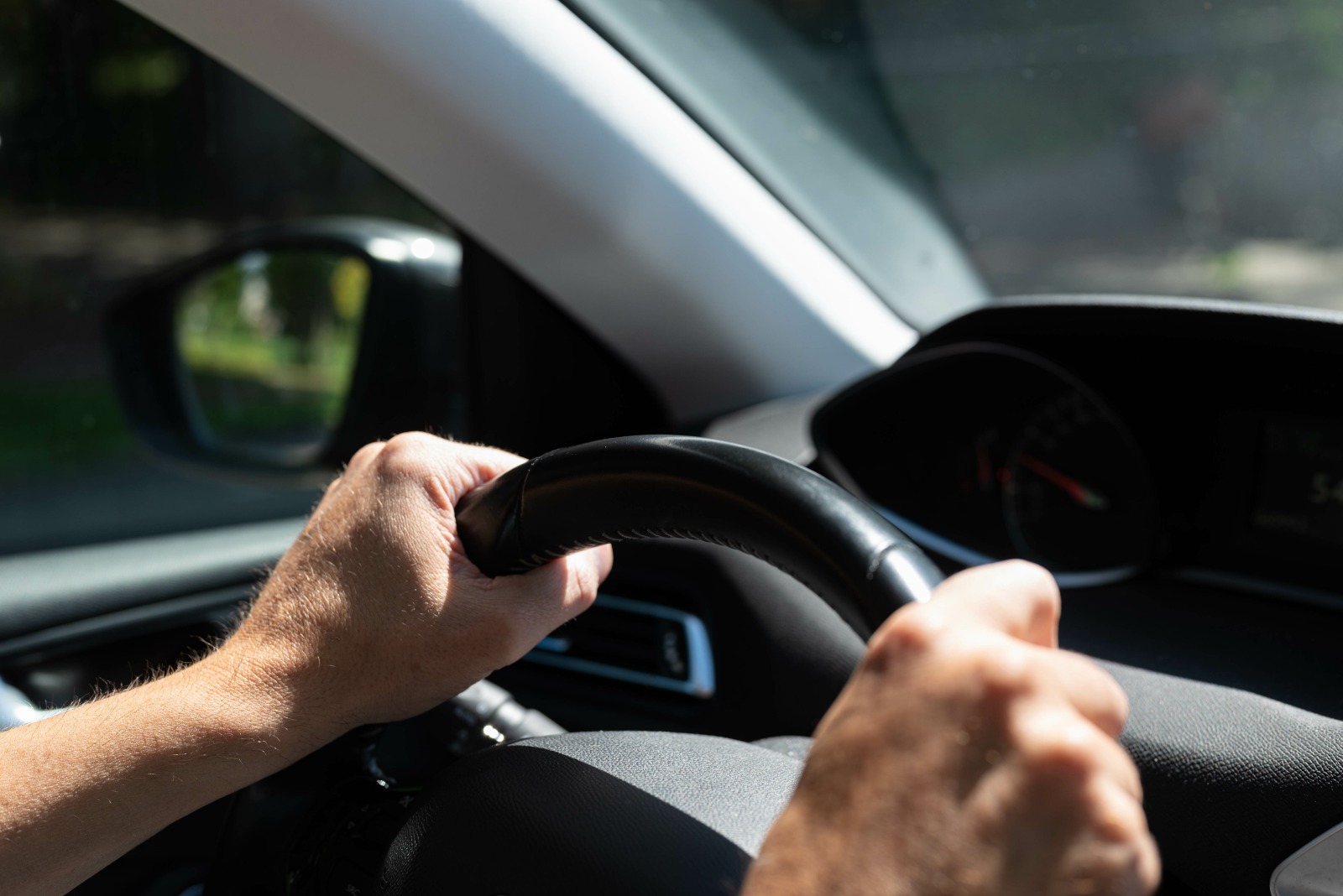 motorista com a mão no volante de um carro em alusão à recomendação para uso regular de frota