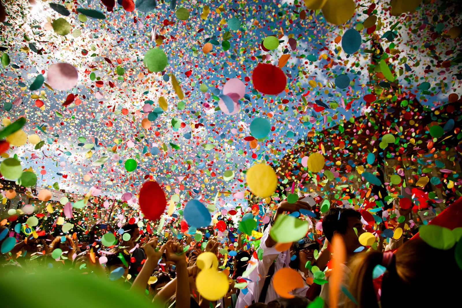 Imagem de foliões pulando o carnaval e confetes sendo jogados