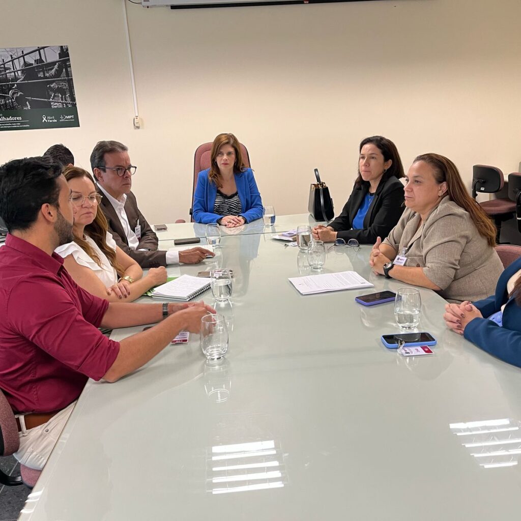 imagem de mesa de reunião com autoridades sentadas ao redor