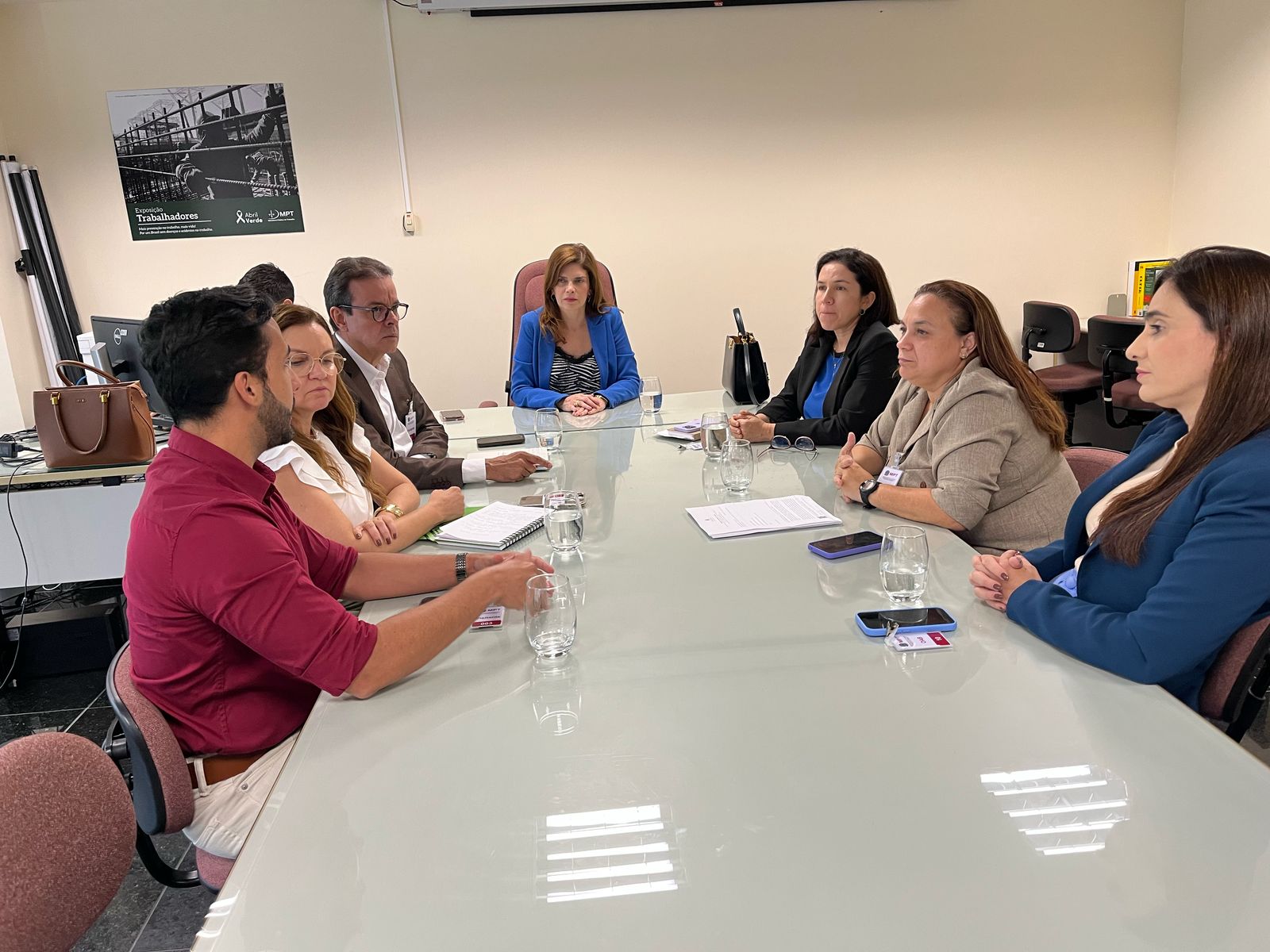 imagem de mesa de reunião com autoridades sentadas ao redor