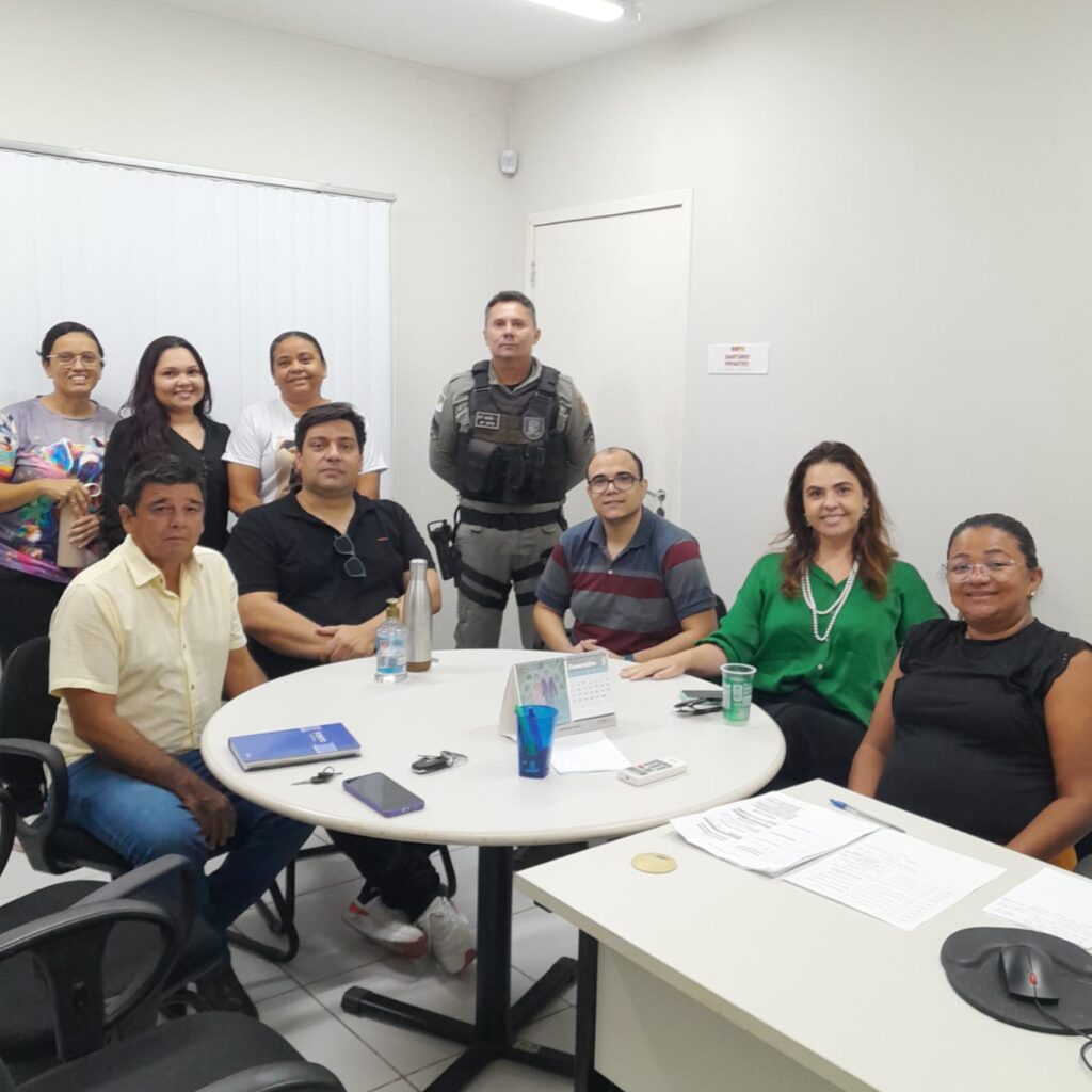 imagem com pessoas sentadas ao redor de uma mesa durante a reuniao