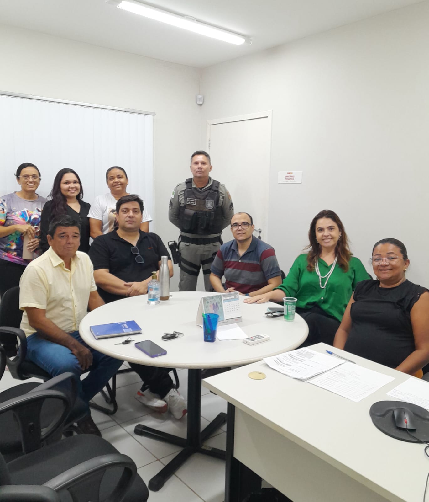 imagem com pessoas sentadas ao redor de uma mesa durante a reuniao